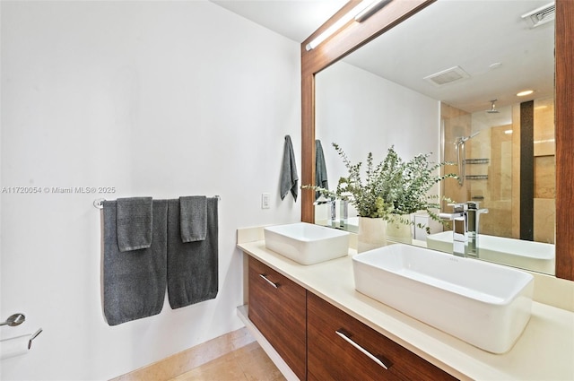 bathroom with tile patterned flooring, vanity, and walk in shower