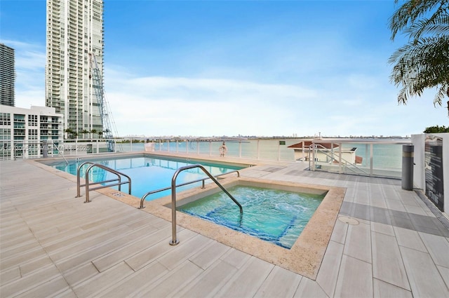 view of swimming pool with a patio area and a hot tub