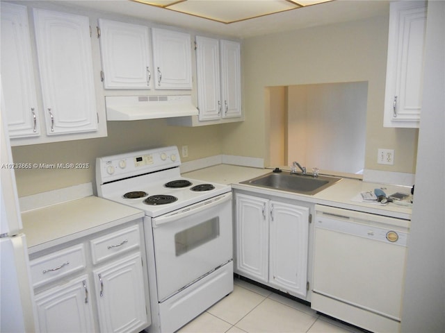 kitchen with light tile patterned flooring, white appliances, sink, and white cabinets