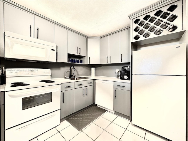 kitchen with light tile patterned flooring, sink, and white appliances