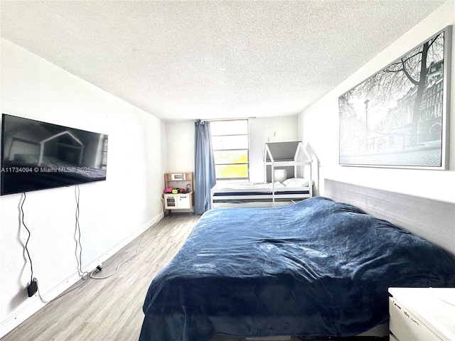 bedroom featuring light hardwood / wood-style floors and a textured ceiling