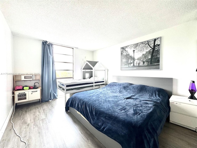 bedroom with hardwood / wood-style floors and a textured ceiling