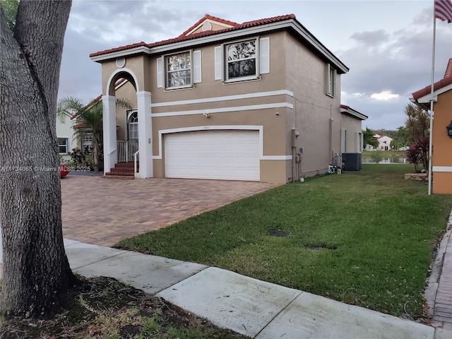 mediterranean / spanish house featuring a garage, a front yard, and cooling unit