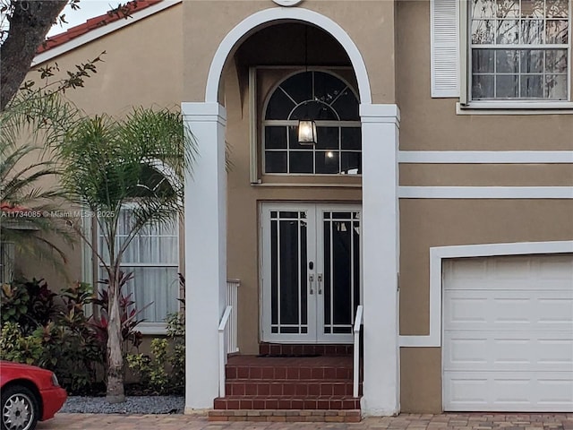 property entrance with a garage and french doors