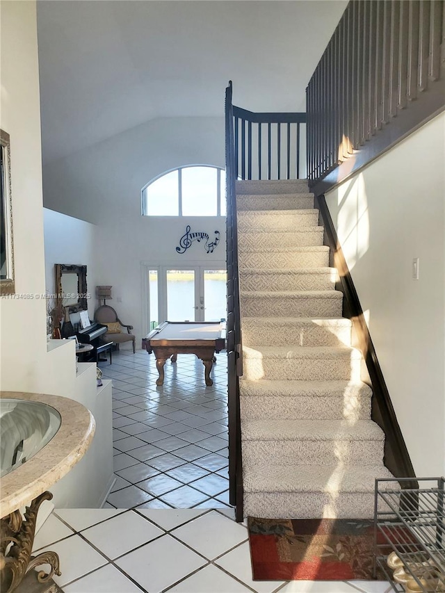 staircase featuring tile patterned flooring, high vaulted ceiling, and french doors