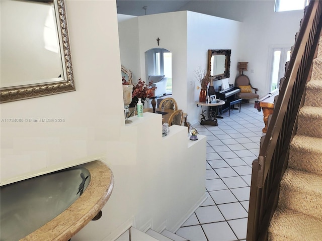 living room with sink, a high ceiling, and light tile patterned floors