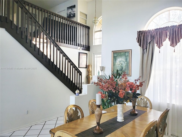 dining space with a towering ceiling and light tile patterned floors