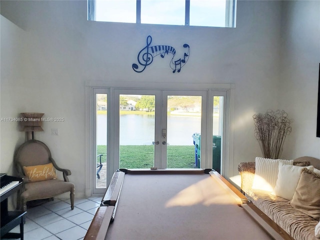 playroom with pool table, french doors, a high ceiling, and a water view