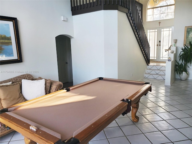 playroom with a towering ceiling, light tile patterned floors, pool table, and french doors