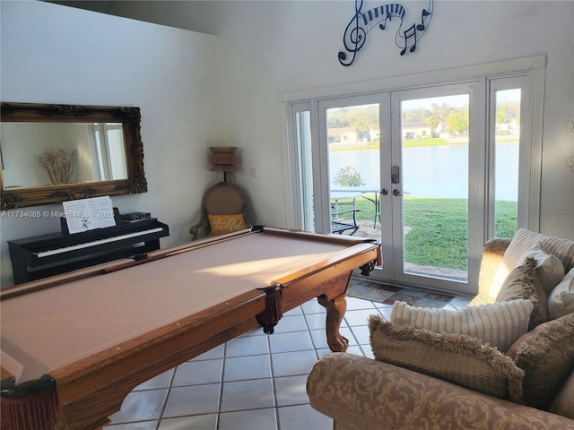 game room featuring light tile patterned floors, french doors, a healthy amount of sunlight, and a water view