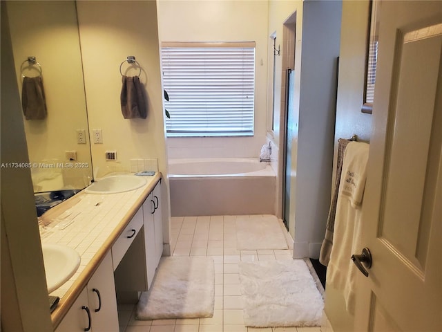 bathroom featuring tile patterned flooring, vanity, and a tub