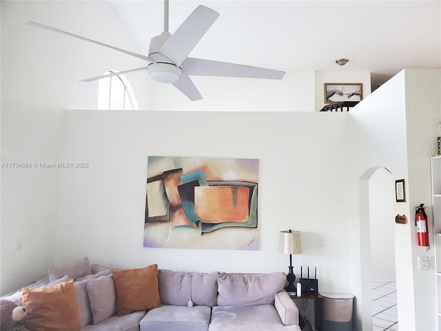 living room featuring ceiling fan and a high ceiling