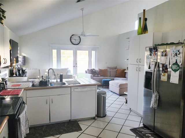 kitchen with sink, stainless steel fridge, dishwasher, white cabinets, and light tile patterned flooring