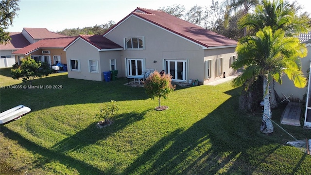 rear view of property featuring a yard and french doors