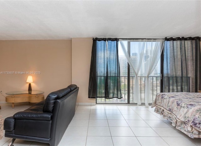 tiled bedroom featuring a textured ceiling and a wall of windows