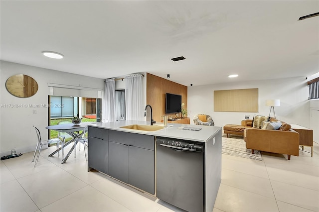 kitchen featuring dishwasher, sink, light tile patterned floors, and an island with sink