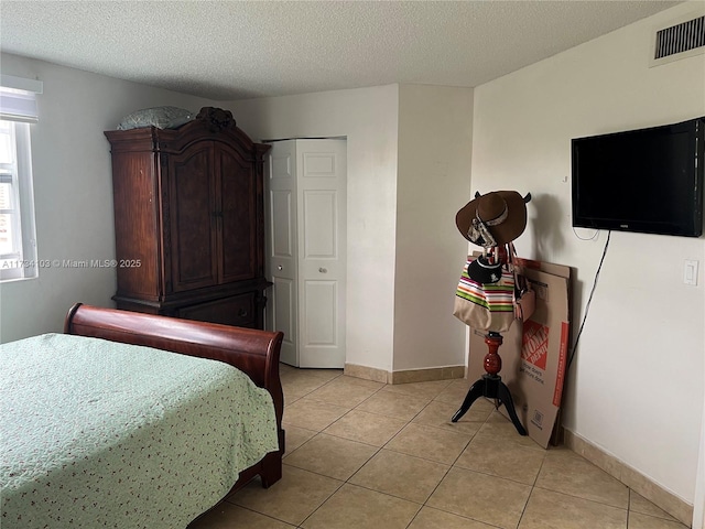 tiled bedroom featuring a textured ceiling