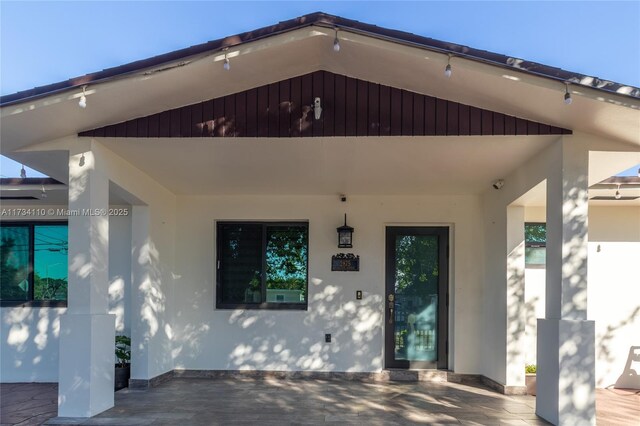 view of exterior entry with a patio area