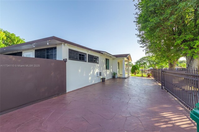 view of property exterior with a patio area