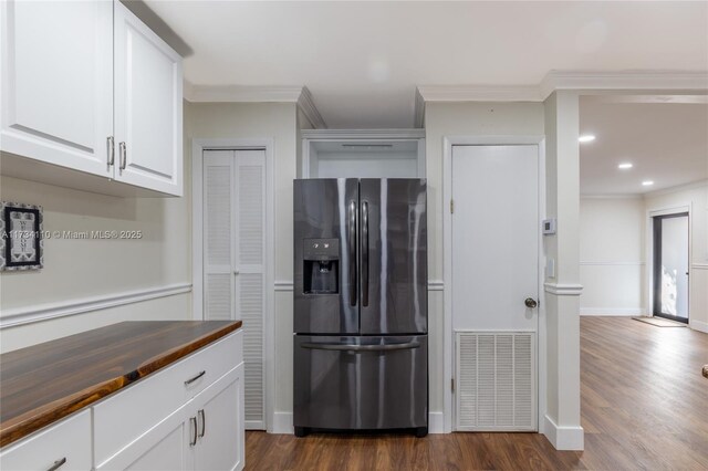 kitchen with white cabinetry, butcher block counters, stainless steel fridge, ornamental molding, and dark wood-type flooring