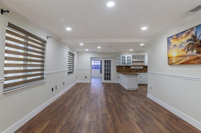 unfurnished living room with ornamental molding, dark hardwood / wood-style floors, and sink