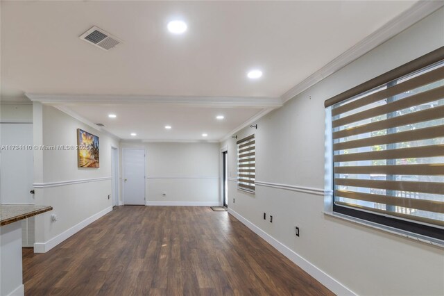 spare room featuring crown molding, dark hardwood / wood-style floors, and a wealth of natural light