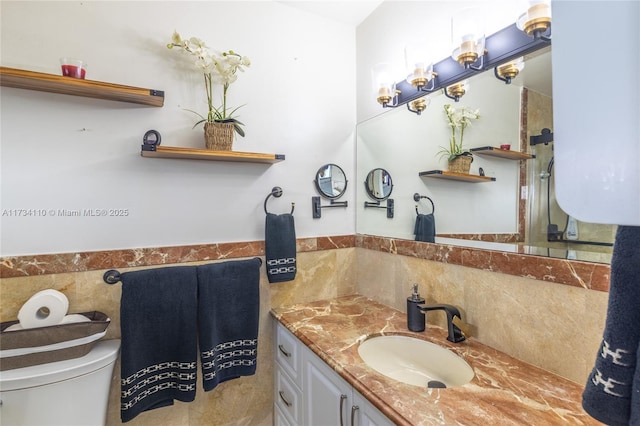 bathroom featuring tile walls, vanity, and toilet