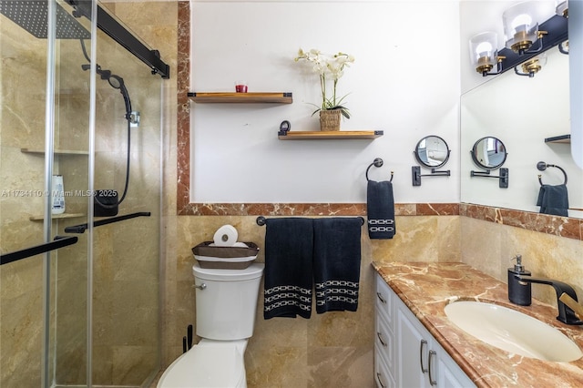 bathroom featuring vanity, toilet, an enclosed shower, and tile walls