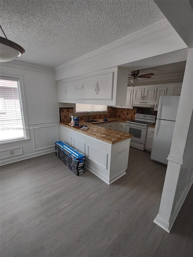 kitchen with sink, white cabinetry, tile countertops, dark hardwood / wood-style flooring, and white appliances