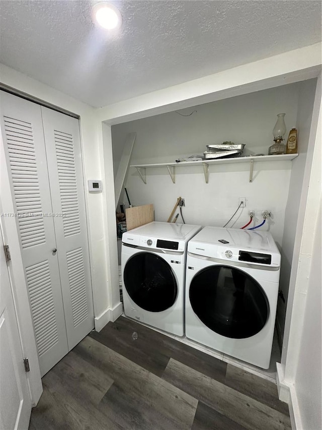 clothes washing area with washing machine and clothes dryer, dark hardwood / wood-style floors, and a textured ceiling