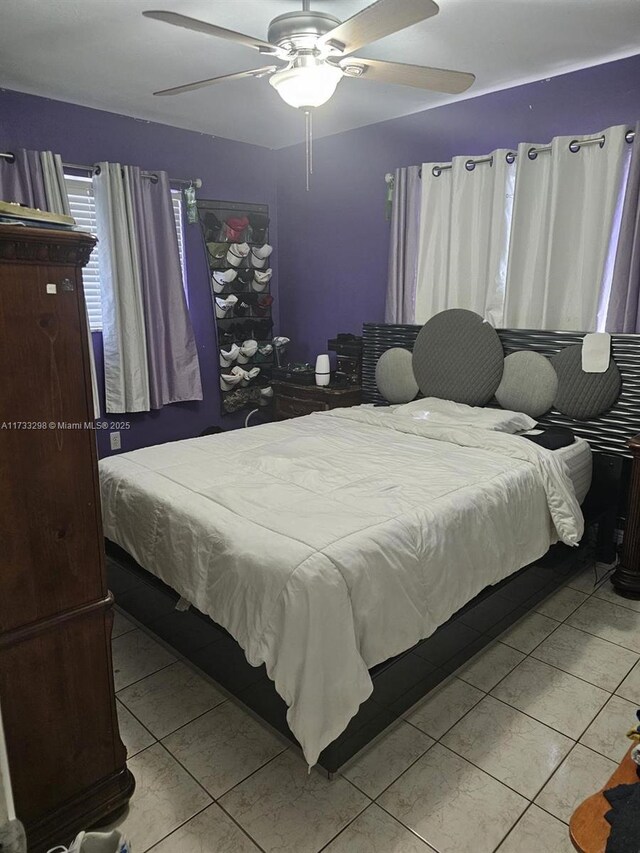 tiled bedroom featuring ceiling fan