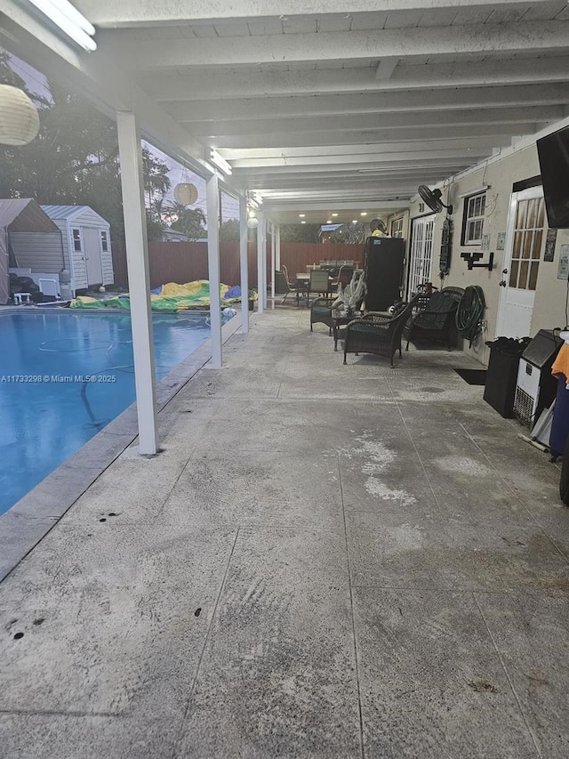 view of pool featuring a storage unit, an outdoor hangout area, and a patio