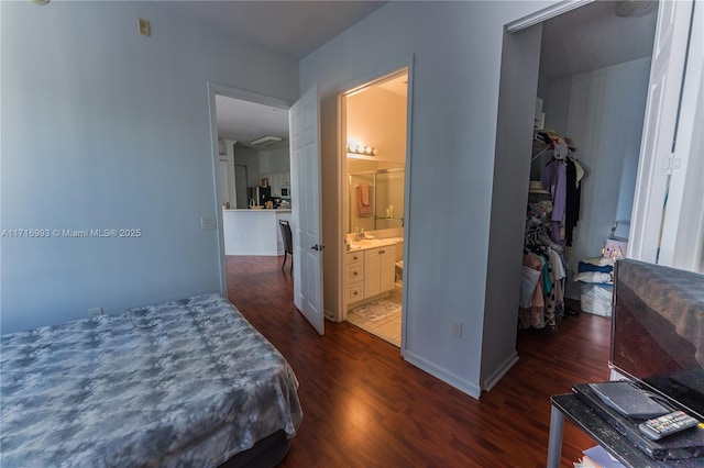 bedroom featuring dark wood-type flooring, ensuite bathroom, and a closet