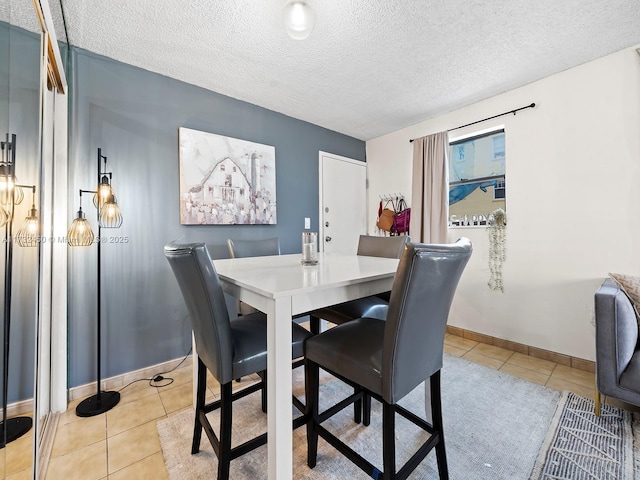 dining room with light tile patterned flooring and a textured ceiling