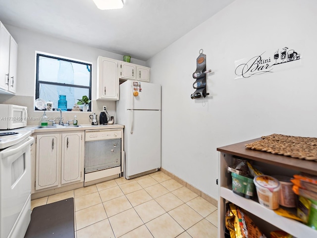 kitchen featuring white cabinetry, sink, white appliances, and light tile patterned floors