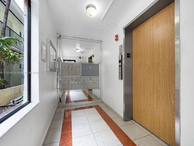 hallway with light tile patterned floors, mail boxes, and elevator