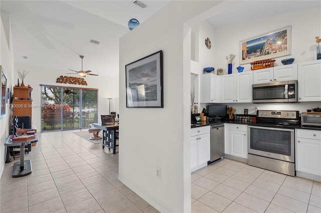 kitchen featuring ceiling fan, stainless steel appliances, light tile patterned floors, and white cabinets