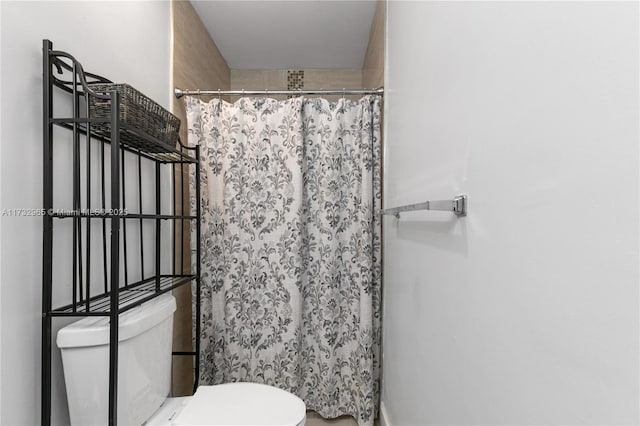 bathroom featuring walk in shower and toilet