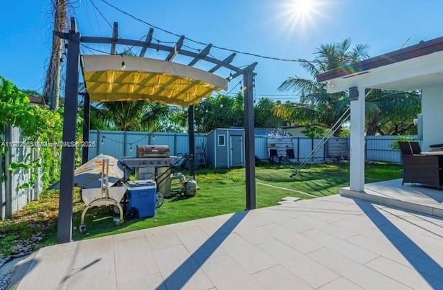 view of patio / terrace with area for grilling, a pergola, and a storage unit