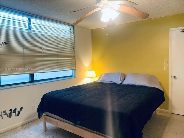 bedroom with multiple windows, ceiling fan, carpet, and a textured ceiling