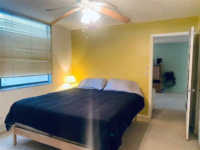 bedroom with ceiling fan, light carpet, and a textured ceiling