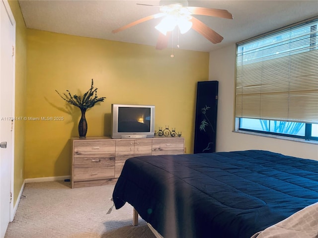 carpeted bedroom with ceiling fan and multiple windows