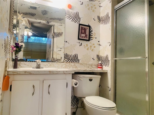 bathroom with vanity, a shower with shower door, and toilet