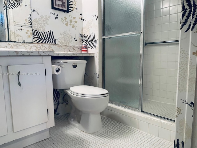 bathroom with tile patterned floors, toilet, a shower with door, and vanity