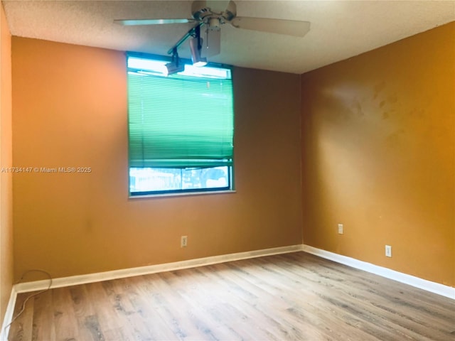 spare room with wood-type flooring and ceiling fan