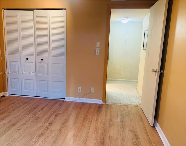 unfurnished bedroom with light hardwood / wood-style floors and a closet