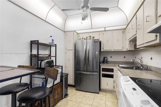 kitchen with white cabinetry, sink, stainless steel refrigerator, and white electric range oven