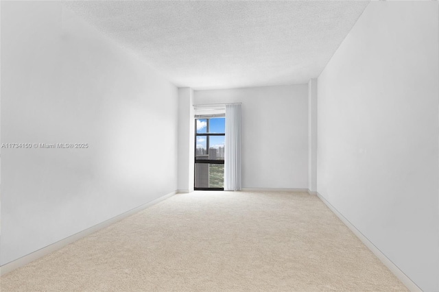 unfurnished room with light carpet and a textured ceiling