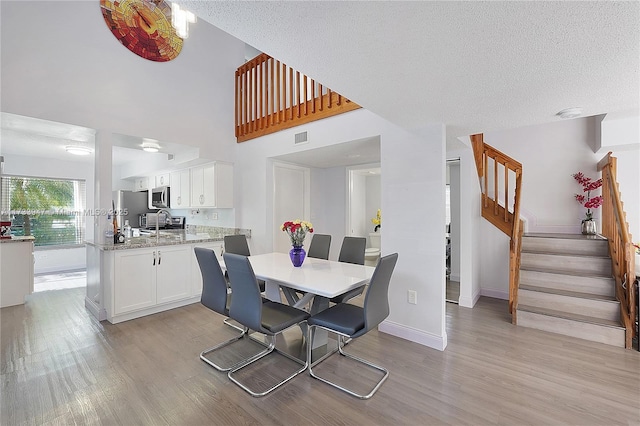 dining area featuring a textured ceiling and light wood-type flooring