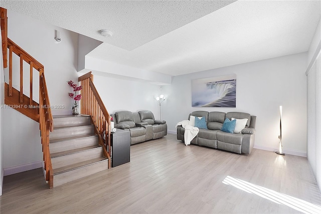 living room featuring light hardwood / wood-style flooring and a textured ceiling